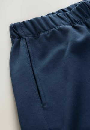 Navy blue pants with an elastic waistband, featuring a side pocket and smooth texture, showcasing clean stitching and a casual design.