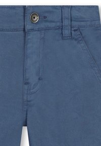 Blauwe denim broeken met een ritssluiting, metalen knoopsluiting en gestikte voorzakken. De stof heeft een gladde, licht gestructureerde afwerking.