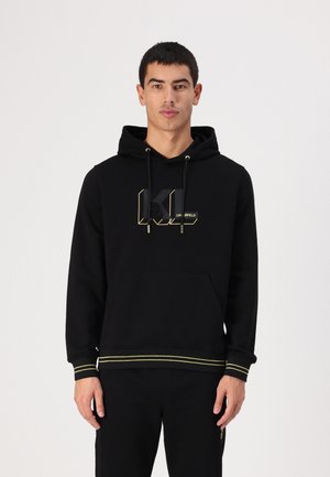 Μαύρη ζακέτα με καπάκι featuring σχεδίαση λογοτύπου σε χρυσό, μπροστινές τσέπες, κορδόνι στην κουκούλα και κίτρινες λωρίδες στους καρπούς και στο τελείωμα. Μαλακή υφή υφάσματος.