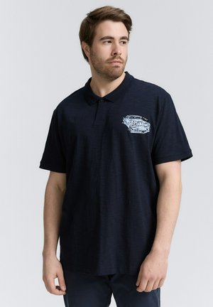 Mörkblå polo skjorta i texturerad tyg, med en liten grafisk design på vänster bröst och en klassisk krage med två knappar.