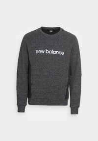 Sudadera gris con cuello redondo y mangas raglán. Presenta un logotipo blanco de "new balance" y paneles laterales en negro. Textura suave.