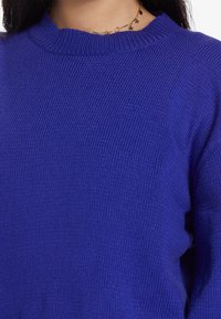 Weicher, gerippter Strickpullover in kräftigem königsblau mit Rundhalsausschnitt. Der Stoff hat ein strukturierte Muster und eine lockere Passform.