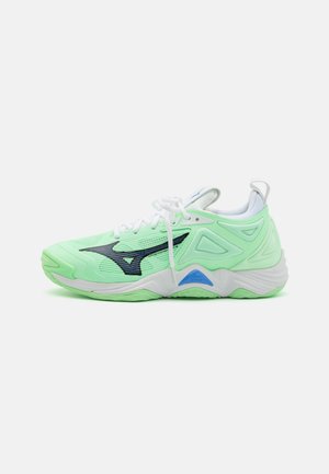 Chaussure de sport vert clair avec un dessus en mesh, détail de logo noir, lacets blancs et col rembourré. Elle dispose d'une semelle texturée pour une bonne adhérence.