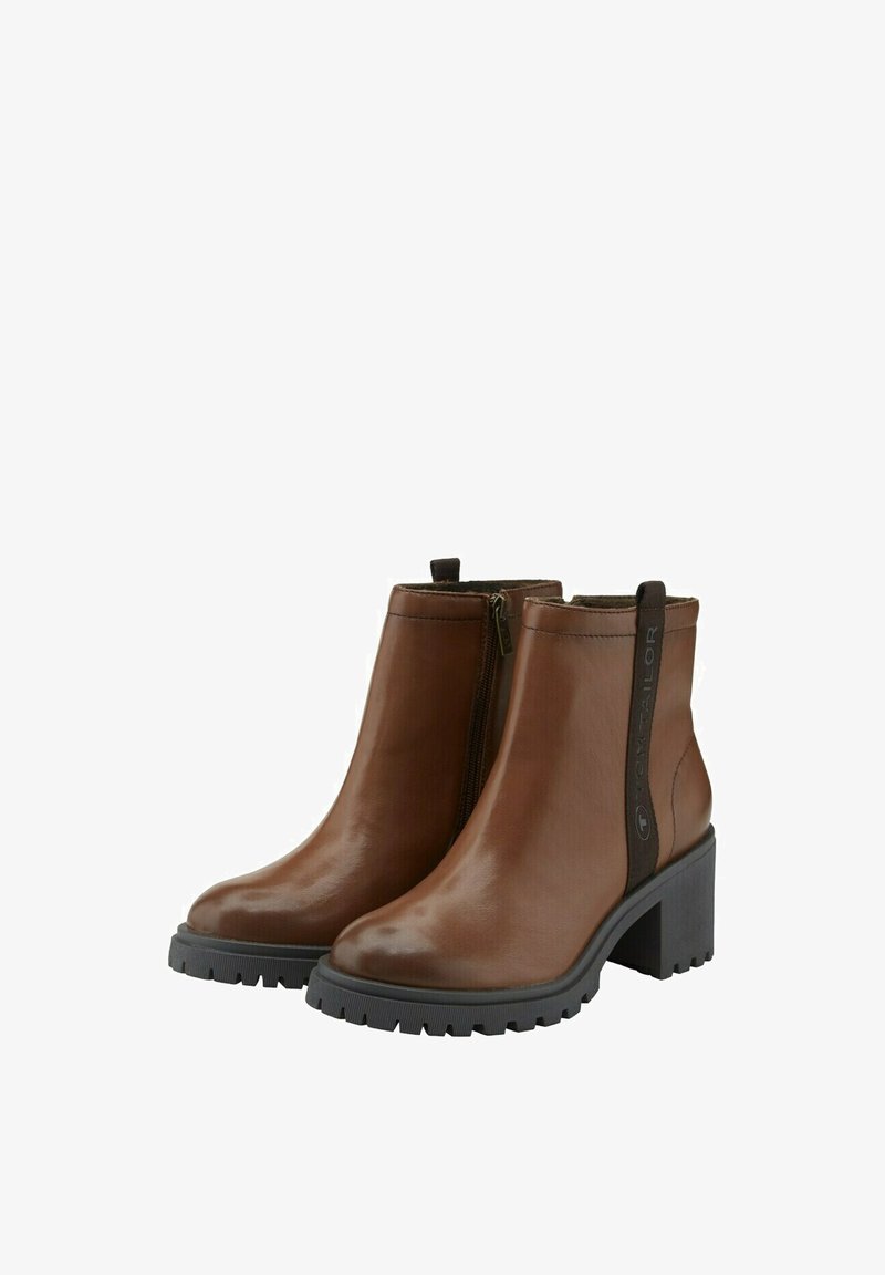 Bottines en cuir marron avec une finition brillante, fermeture éclair sur le côté et un talon en caoutchouc noir épais. Présente une semelle texturée pour une meilleure adhérence.