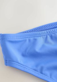 Lyseblå bikiniunderdel lavet af glat, elastisk stof. Har en syet linning og rynkede sider for en tæt pasform.