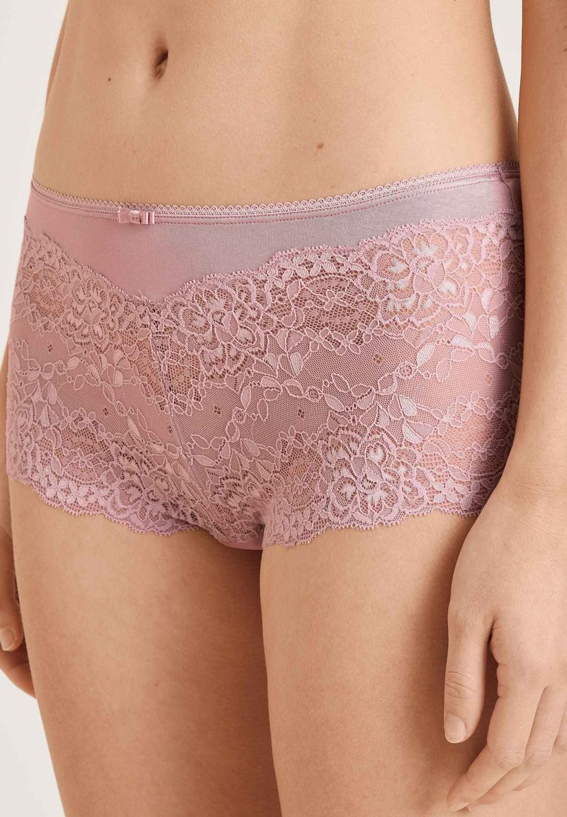 Roze kanten hipsterondergoed met florale kantdetails, een zachte mesh tailleband en een klein strikaccent aan de voorkant.