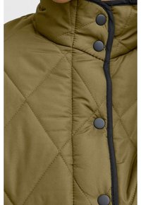 Giacca imbottita verde oliva con colletto alto, dotata di bottoni a pressione neri lungo la parte anteriore e rifiniture nere a contrasto lungo le cuciture.