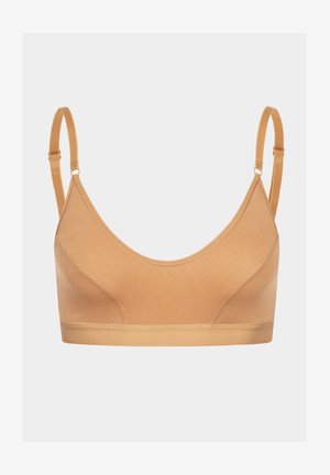 Beige drahtloser BH mit Rundhalsausschnitt und verstellbaren Trägern. Hergestellt aus weichem Stoff mit einer glatten Textur und minimalen Nähten.