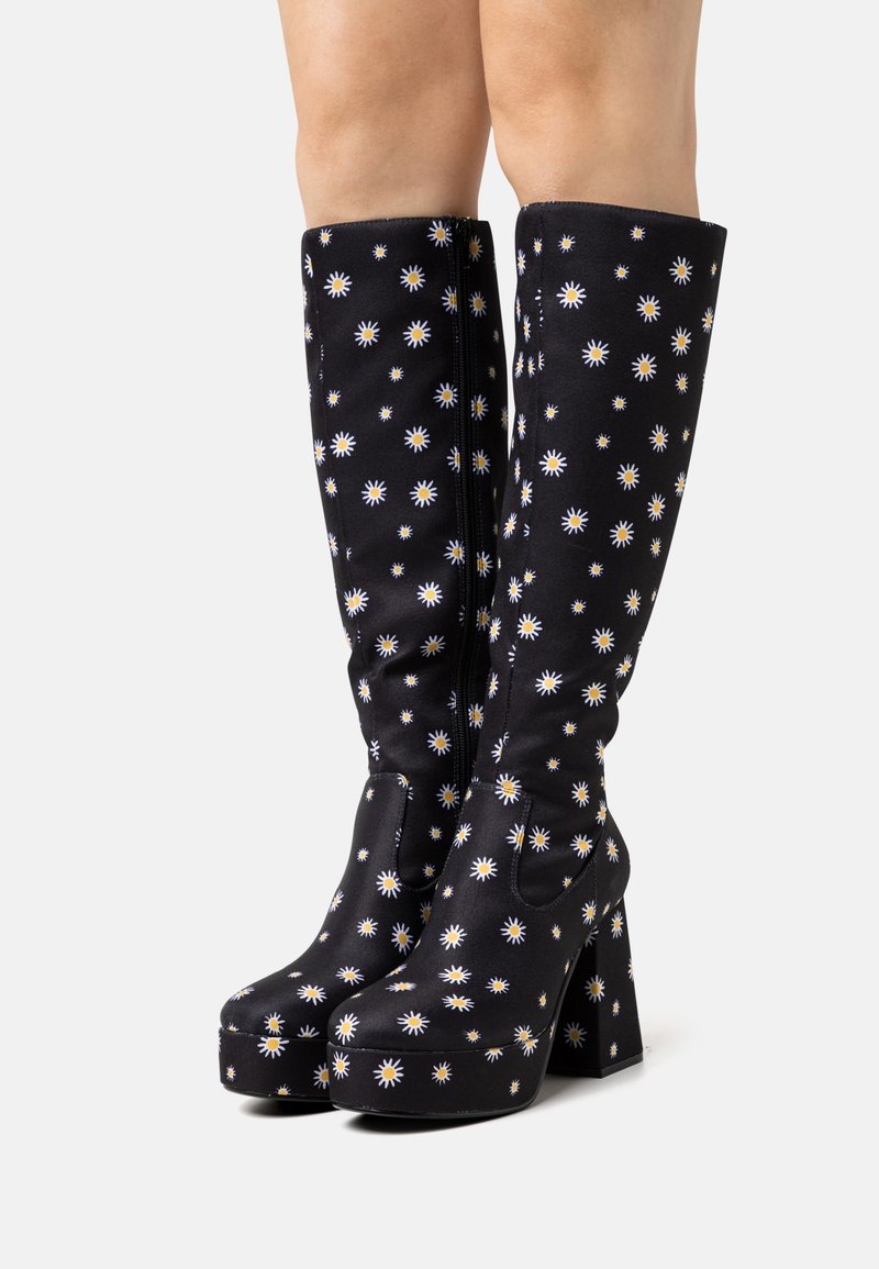 Czarne kozaki za kolano z motywem kwiatów stokrotek, wyposażone w platformę i masywny obcas, wykonane z gładkiej tkaniny, z zamkiem błyskawicznym.
