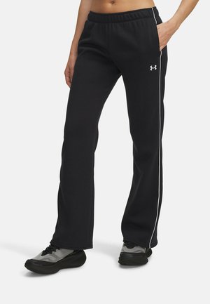 Black athletic pants with an elastic waistband, white side stripes, and soft fabric. Paired with dark, patterned sneakers.
