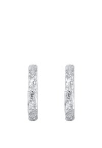 Orecchini a cerchio in argento con una superficie testurizzata, caratterizzati da una forma leggermente irregolare. Il design è minimalista e riflettente.