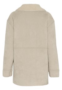 Beige tekonahkapintainen takki, jossa on pehmeä, kermaisenvalkoinen shearling-kaulus. Ylisuurta mitoitusta ja laskeutuva olkalinja. Sileä pinta, ei näkyviä kiinnityksiä.
