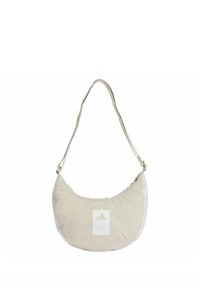 Bolso de tela beige para llevar al hombro con una forma curva, que presenta un panel blanco, un parche con el logo y una correa delgada. Superficie texturizada con detalles fruncidos.
