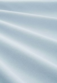 Svetlo modra tkanina z gladko teksturo, ki prikazuje subtilne diagonalne valovite gube in enakomeren vzorec majhnih, dvignjenih pik.