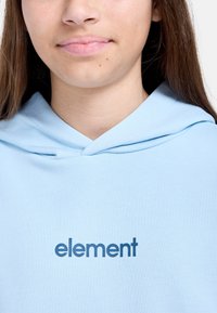 Lichtblauwe hoodie van zachte stof, met een voorste kangoeroezak en een gedrukte logo "element" in donkerblauw op de borst.