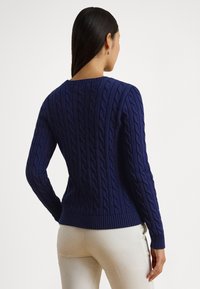 Temno modro pleten pulover z vrvico, s črtasto robno in manšetami, z teksturiranimi navpičnimi vzorci in klasičnim okroglim izrezom.