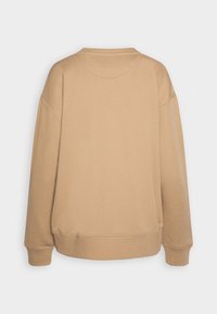 Sudadera beige de gran tamaño con hombros caídos, puños acanalados, cuello redondo y una textura suave y lisa. Diseño de espalda liso, sin patrones.