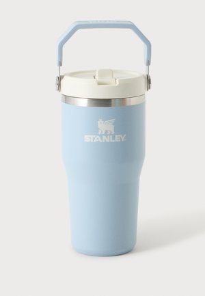 Gobelet de voyage isolé Stanley bleu clair avec couvercle blanc et poignée pliable sur fond uni.