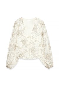 Valkoinen paita, jossa on monimutkainen beige kukkataiteilu, syvä V-pääntie ja pitkät puffihihat. Sisältää sidottavan etuläpän ja kevyen kankaan.