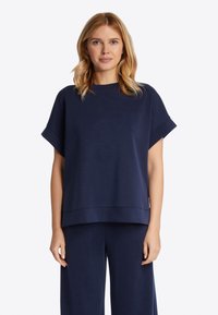 Marineblauwe oversized korte mouwen top van een zachte stof met een ronde hals en een rechte zoom, gecombineerd met bijpassende losse broek.