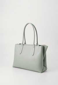 Svetlo zelena usnjena torba z dvema trdnima ročajema, pravokotne oblike in gladke teksture. Brez vidnih vzorcev ali kovinskih dodatkov.