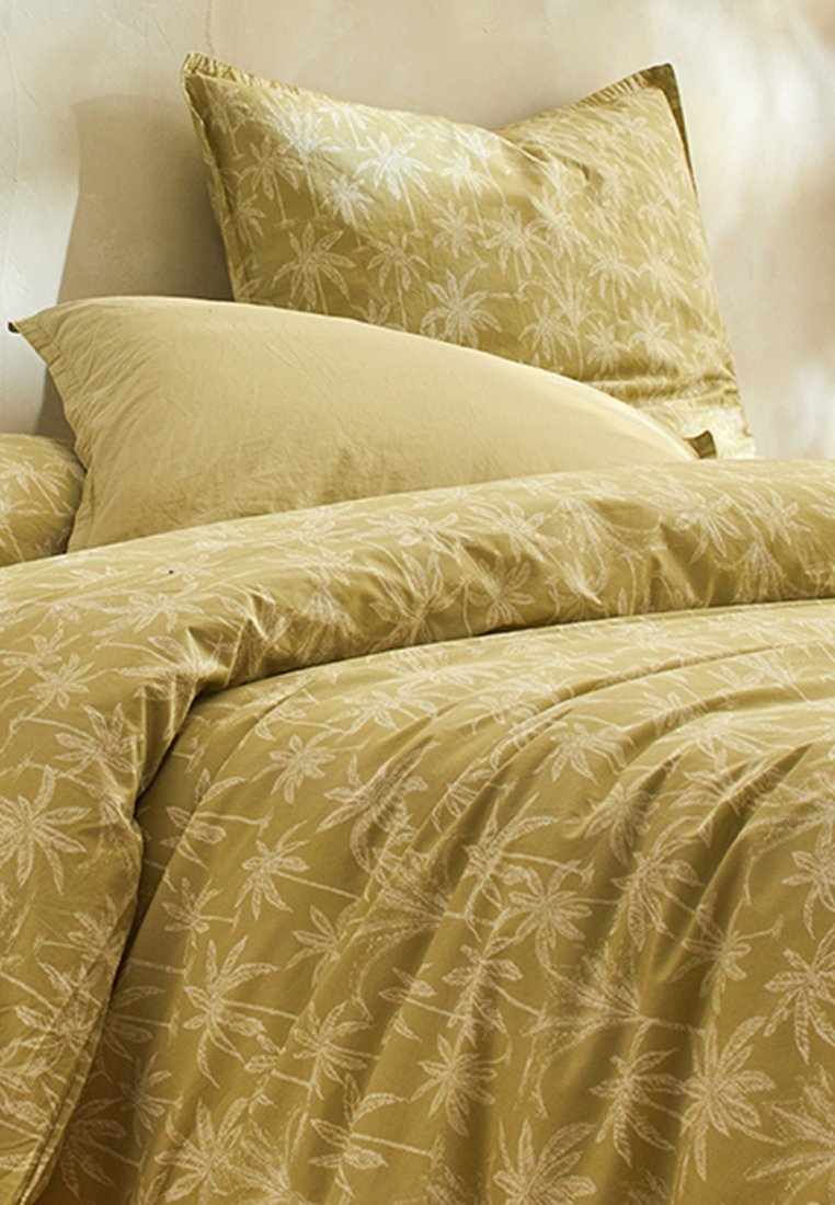 Ensemble de literie jaune avec un motif de feuilles florales blanches. Comprend une housse de couette, deux oreillers et une texture lisse et douce.