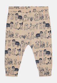 Beige leggings med ett mönster av hundar i marinblått som visar olika raser, med detaljerade konturer, smal passform och elastisk midja.