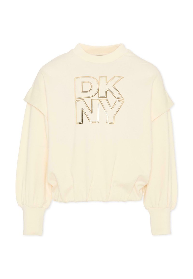 Felpa color crema con polsini e orlo a coste. Presenta la scritta "DKNY" in stampa metallica dorata. Tessuto morbido e design a vestibilità rilassata.
