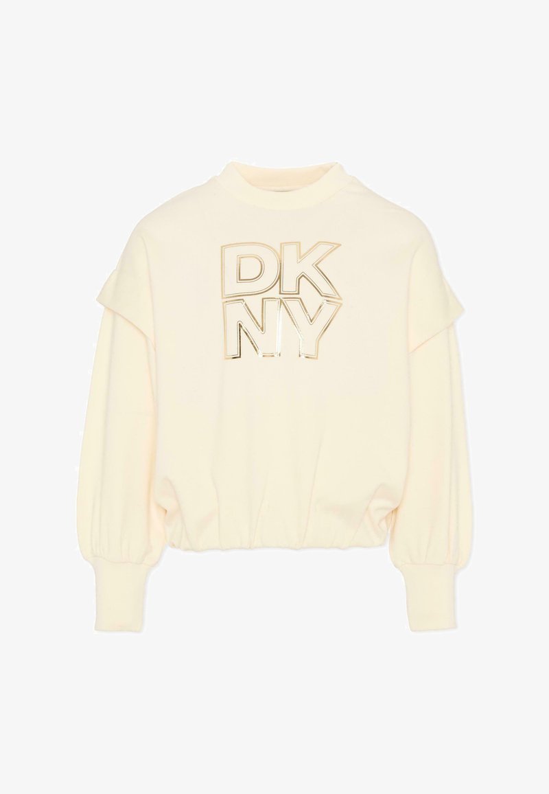 Felpa color crema con polsini e orlo a coste. Presenta la scritta "DKNY" in stampa metallica dorata. Tessuto morbido e design a vestibilità rilassata.