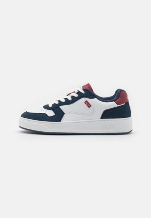 Białe sneakersy z granatowymi zamszowymi akcentami, okrągłym noskiem, grubą gumową podeszwą i logo na czerwonym tabelem. Posiadają białe sznurowadła i wyściełany kołnierz dla wygody.