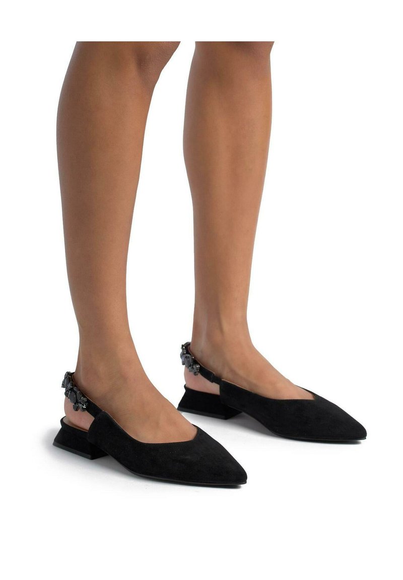 Ballerine slingback in suede nero con punta affusolata e tacco basso e chunky. Presentano dettagli decorativi sul tacco e una superficie liscia e testurizzata.