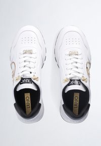 Sneaker bianchi con tomaia in pelle texturizzata, hardware con accenti dorati, design con lacci e dettagli interni neri.