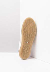 Weiße Sneakers mit einer Sohle aus Gummi, die ein strukturiertes Profilmuster aufweist. Logodetail in die Sohle eingearbeitet, mit Akzenten in den Farben der italienischen Flagge.