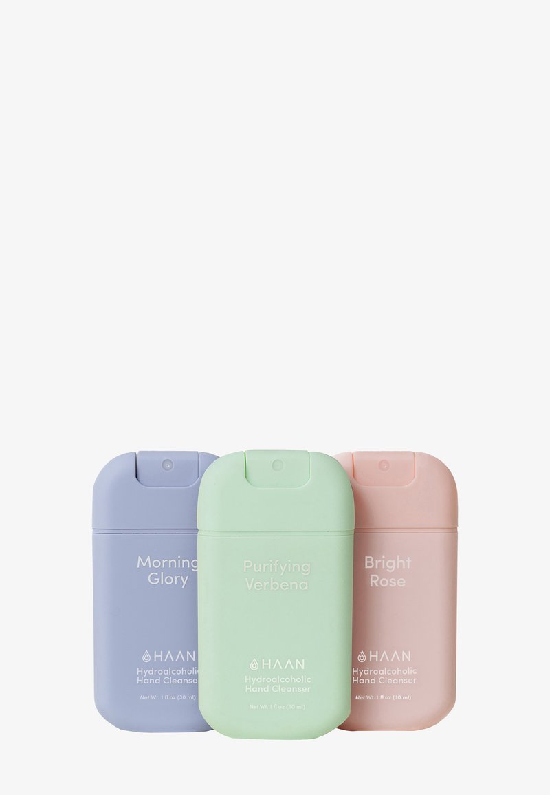 Tre detergenti per le mani in colori pastello: lavanda, verde e rosa. Ognuno presenta un design arrotondato e portatile con un tappo a ribalta.