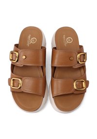 Sandali slide in finta pelle marrone con due cinturini regolabili e fibbie dorate, dotati di una suola piatta bianca e una texture liscia.