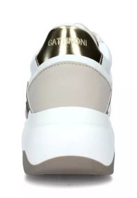 Zapatilla blanca con un talón acentuado en dorado y paneles laterales en beige, que presenta materiales suaves y un diseño de suela gruesa. Branding de Gattinoni visible.