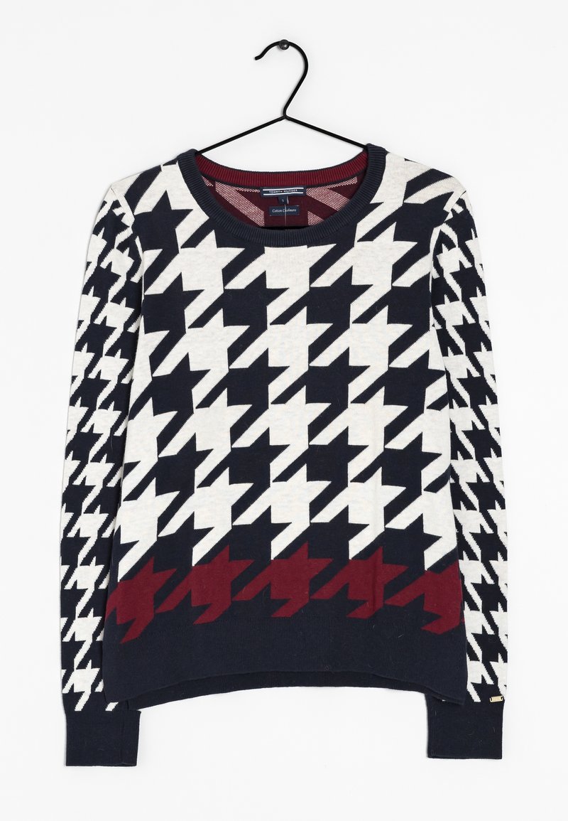Il maglione presenta un motivo a scacchi in bianco, nero e bordeaux. Realizzato in tessuto lavorato a maglia, ha un collo rotondo e maniche lunghe.