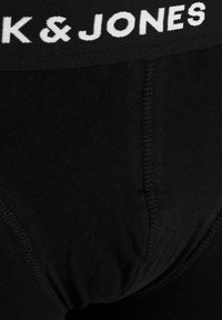 Schwarze Baumwoll-Boxershorts mit einem weißen elastischen Taillenbund, der "K & JONES" zeigt. Merkmale sind die glatte Textur, das enganliegende Design und flache Nähte.