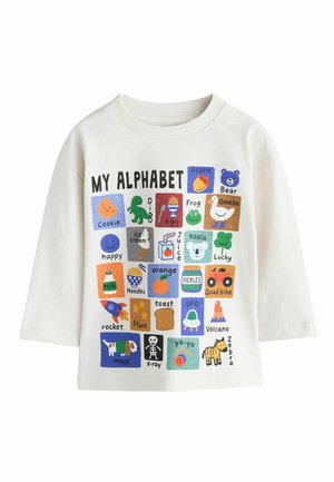 Biela košeľa s dlhým rukávom s farebnými blokmi abecedy zobrazujúcimi objekty a zvieratá ako cookie, dinosaurus, vajce, žaba, koala a zebra.