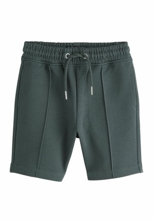 Dunkelgrüne Strickshorts mit elastischem Bund, vorderem Kordelzug, zwei Seitentaschen und vorderer Nahtdetails.