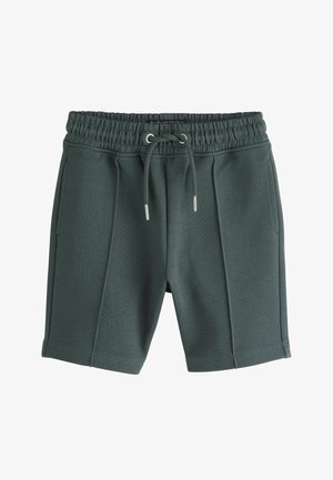 Ciemnozielone dzianinowe szorty z elastycznym pasem, sznurkiem z przodu, dwoma bocznymi kieszeniami i przeszyciami z przodu.