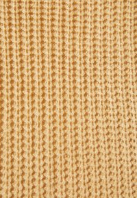 Tessuto in maglia gialla con una superficie testurizzata. Presenta righe verticali e punti aperti uniformemente distribuiti in tutto il design.
