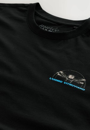 T-shirt en coton noir avec un contour blanc du dessin de l'Homme de Vitruve et le texte "L'uomo Vitruviano" en bleu. Design à col rond.