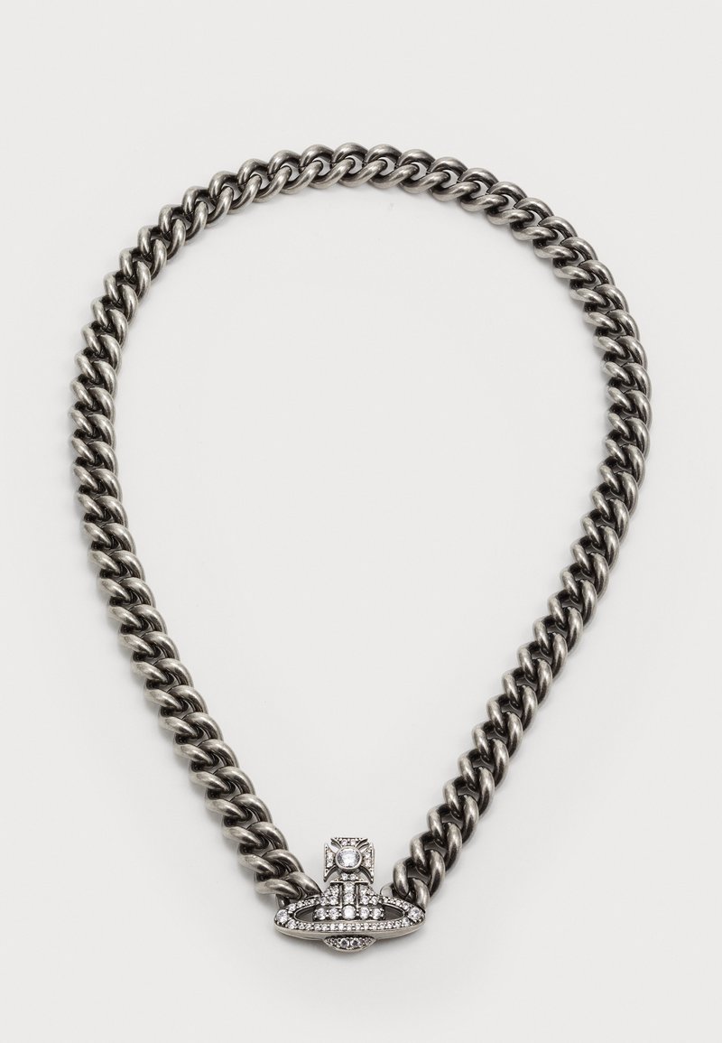 Collana in metallo con un design a maglia spessa in argento scuro. Presenta un prominente centro incastonato di cristalli con una forma circolare rialzata.