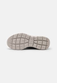 Shoe sole with textured white rubber, featuring a grid pattern and grooves for traction, designed for performance and comfort.
