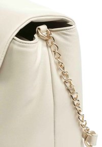 Crèmekleurige leren handtas met een gestructureerde afwerking, voorzien van een gouden kettinkje en een klepsluiting.