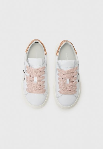 Hvite sneakers med en glatt læroverdel, rosa flettede snører og en metallisk beige detalj på hælen. Rund tå med embossed merking.