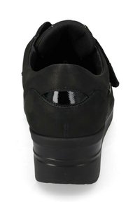 Scarpa ortopedica nera con colletto imbottito, cinturino in velcro e suola spessa e ammortizzata vista da dietro.