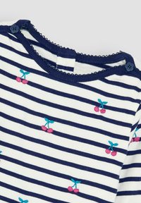 Gestreiftes Hemd mit marineblauen und weißen Linien, das kleine bestickte rosa Kirschen mit blauen Stielen zeigt. Wellenförmiger Ausschnitt und Knopfdetails.