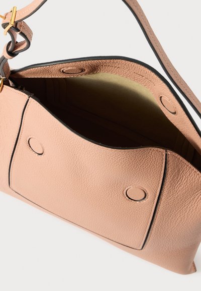Lyserød tekstureret læder crossbody-taske med magnetisk klaplukning og justerbar rem, vist åben for at afsløre tomt indre.